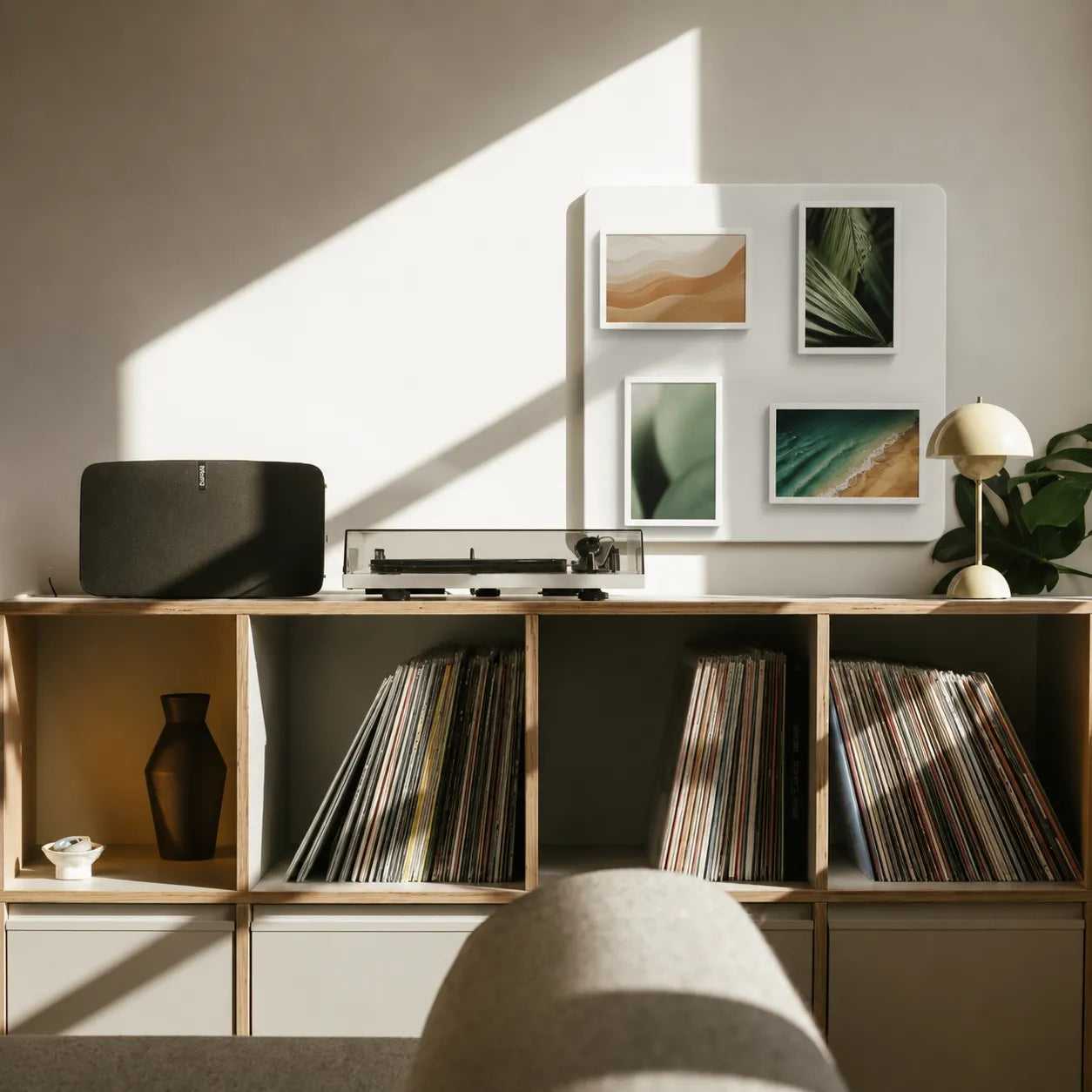 Pintura cordless digital frames displaying nature photography on a wall above a vinyl record cabinet.