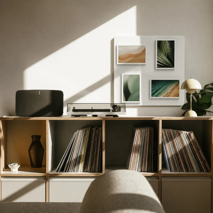 Pintura cordless digital frames displaying nature photography on a wall above a vinyl record cabinet.
